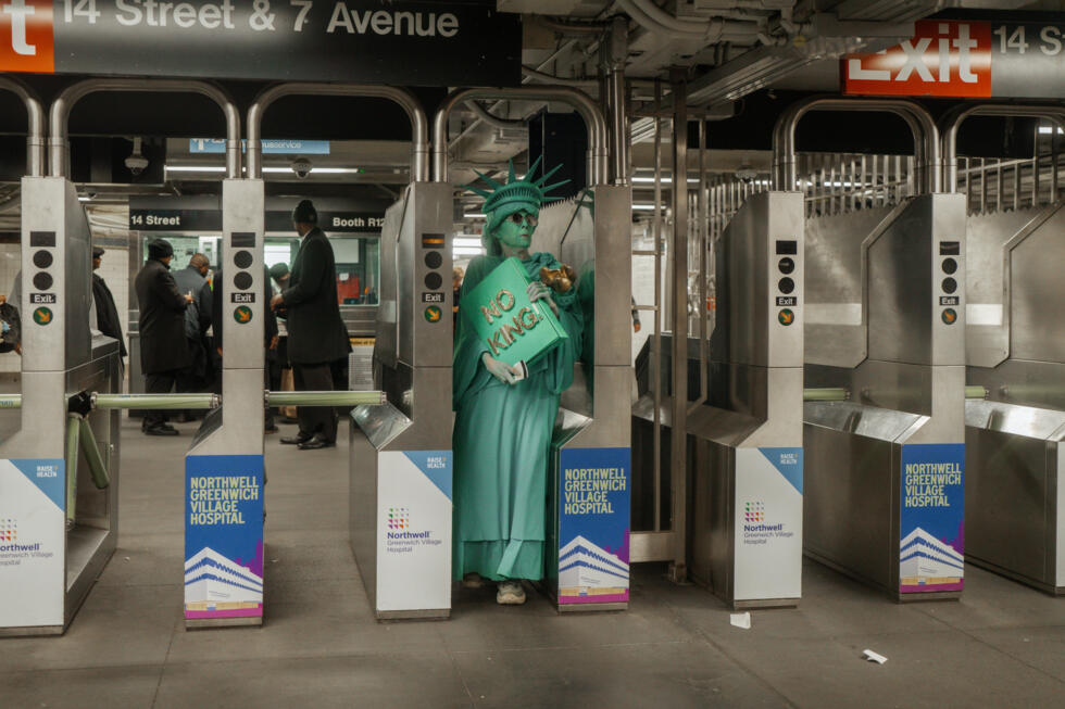 A protester dressed in a Statue of Liberty costume enters a New York subway station after a "No Kings" protest October 18, 2025.