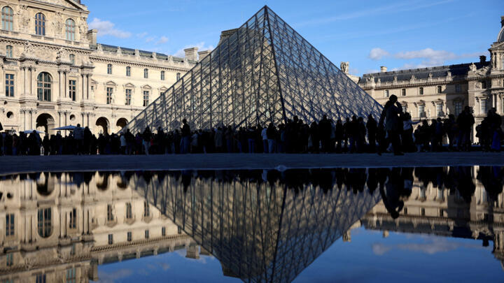 People stand outside the Louvre Museum, after French police arrested suspects in the Louvre heist case, in Paris, France October 26, 2025