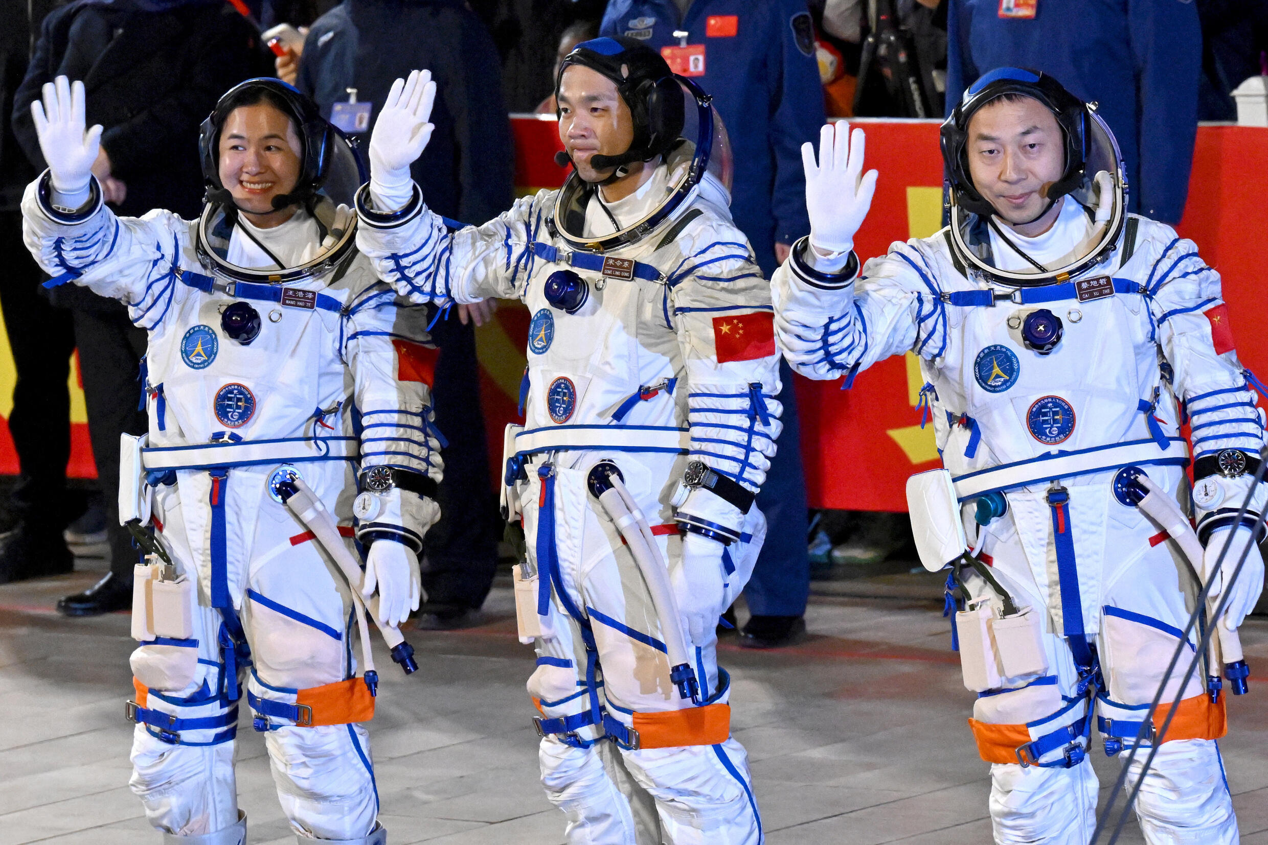 Les astronautes Cai Xuzhe (droite), Song Lingdong (centre) and Wang Haoze saluent la foule avant leur départ pour la station spatiale Tiangong, le 30 octobre 2024, au centre de lancement chinois de Ji