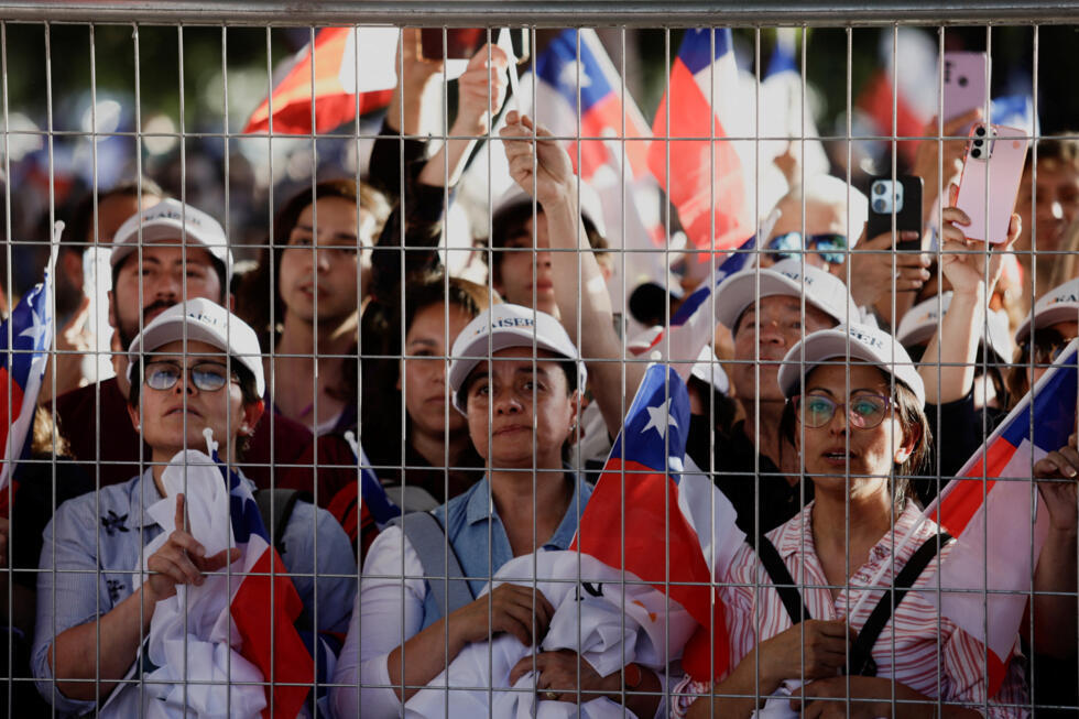 Simpatizantes de Johannes Kaiser, candidato presidencial del ultraderechista Partido Libertario Nacional, ondean banderas chilenas durante su mitin de cierre de campaña, previo a las elecciones presidenciales del 16 de noviembre, en Santiago de Chile, el 12 de noviembre de 2025.