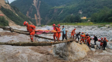 Rescatistas trasladan a un herido durante el terremoto en la provincia de Sichuan a través de un puente improvisado en la ciudad de Moxi, condado de Luding, el 5 de septiembre de 2022.