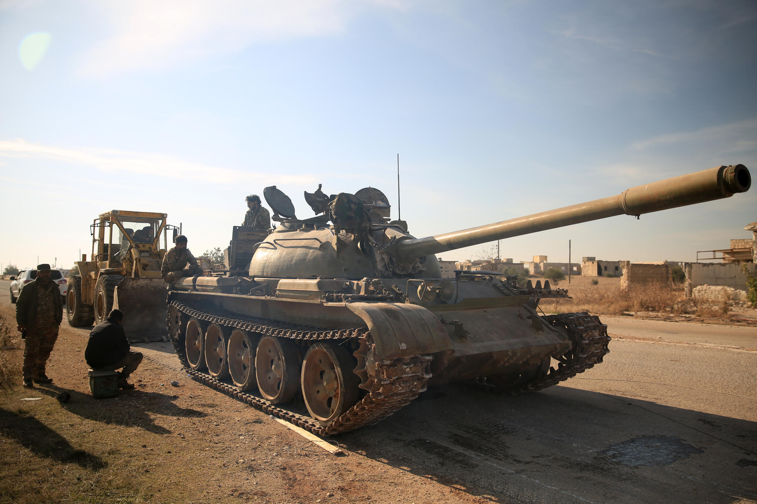 Des combattants antigouvernementaux inspectent un char abandonné par les forces kurdes dans la ville de Tal Rifaat, dans la province d'Alep dans le nord de la Syrie, le 2 décembre 2024