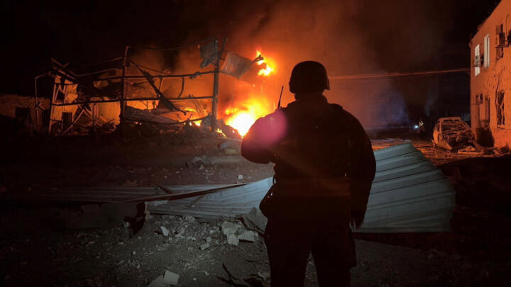 A firefighter looks at a building burning after it was hit during overnight Russian drone and air strikes, amid Russia's attack on Ukraine, in Zaporizhzhia, Ukraine on October 5, 2025.