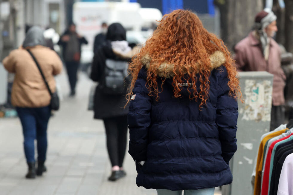An Iranian woman, not wearing the mandatory hijab, walks in a street in the capital Tehran on December 12, 2024. Iranian President Masoud Pezeshkian has expressed doubts about new legislation imposing
