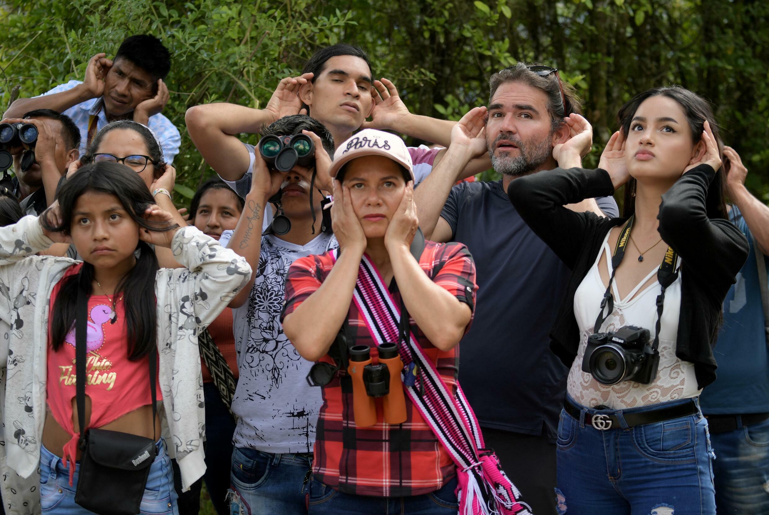 Colombian ornithologist Diego Calderon (second from right) shows the group how to listen to birds
