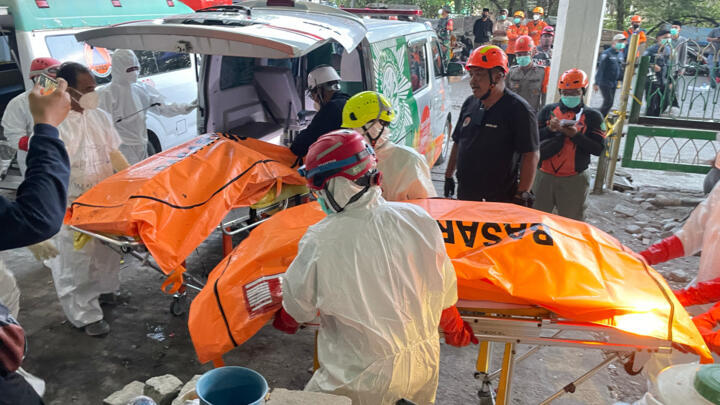 Rescuers put bodies of victims from a collapsed building at an Islamic boarding school into an ambulance in Sidoarjo, East Java, Indonesia on October 3, 2025.