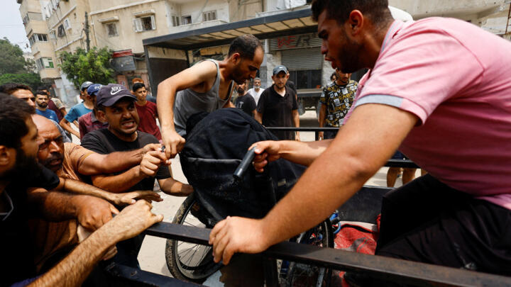 Palestinians carry a casualty following an Israeli airstrike, in Gaza City, August 12, 2025.
