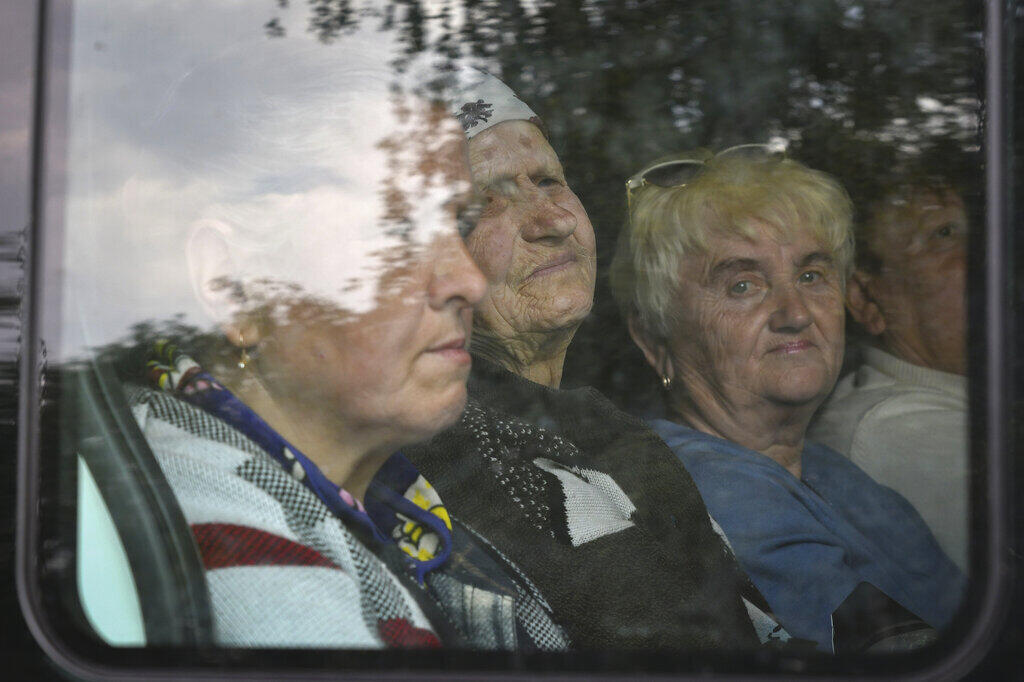 Ancianas ucranianas sentadas en el autobús durante una evacuación de civiles en Soledar, región de Donetsk, Ucrania, martes 24 de mayo de 2022.