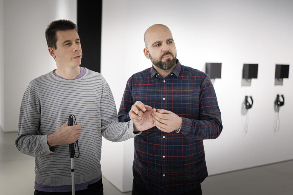 Olivier Mamini (g.) et son chuchoteur d'images Pierre-Antoine Possa participent à une visite guidée pour les personnes malvoyantes au Musée international de la Croix-Rouge et du Croissant-Rouge à Genève, le 30 mars 2025