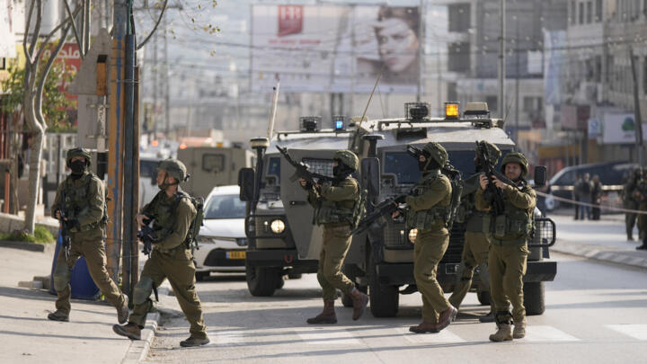Israeli soldiers take up positions at the scene of a Palestinian shooting attack at the Hawara checkpoint, near the West Bank city of Nablus, Sunday, Feb. 26, 2023.