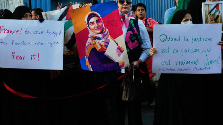 Demonstrators hold portraits of Mahdieh Esfandiari, an Iranian national detained in France, during a protest in front of the French Embassy in Tehran to demand her release October 21, 2025.
