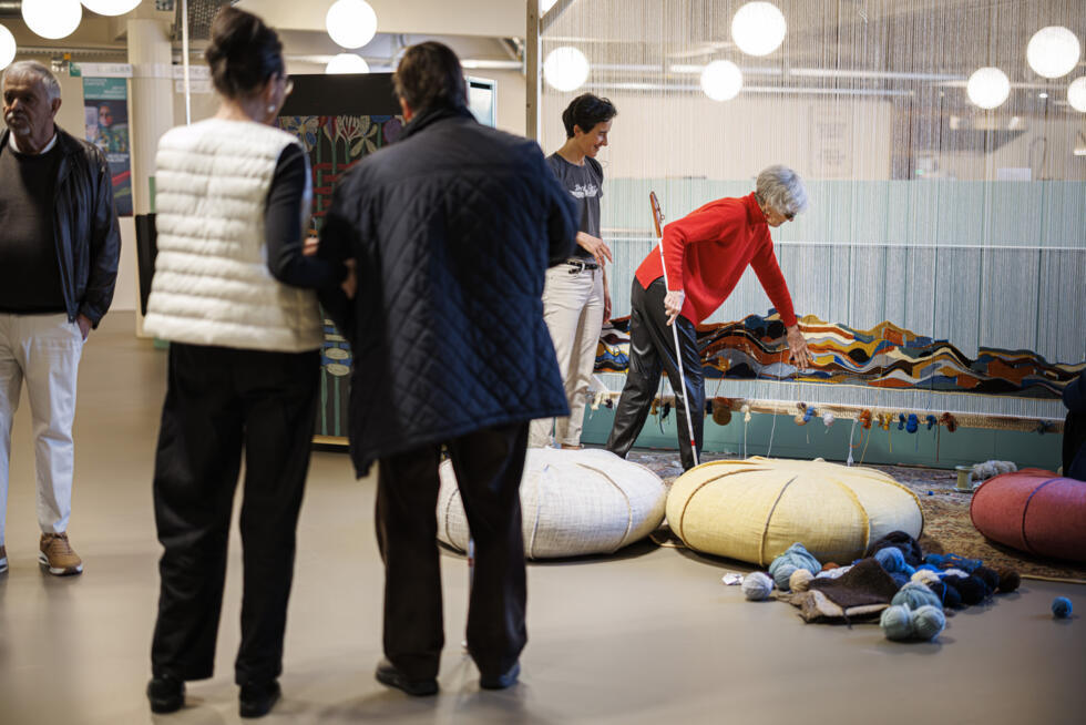 Waltraud Quiblier (d.) touche une installation artistique à côté de sa chuchoteuse d'images Cécile Crassier Mokdad (2e à d.) lors d'une visite guidée au Musée international de la Croix-Rouge et du Croissant-Rouge à Genève, le 30 mars 2025