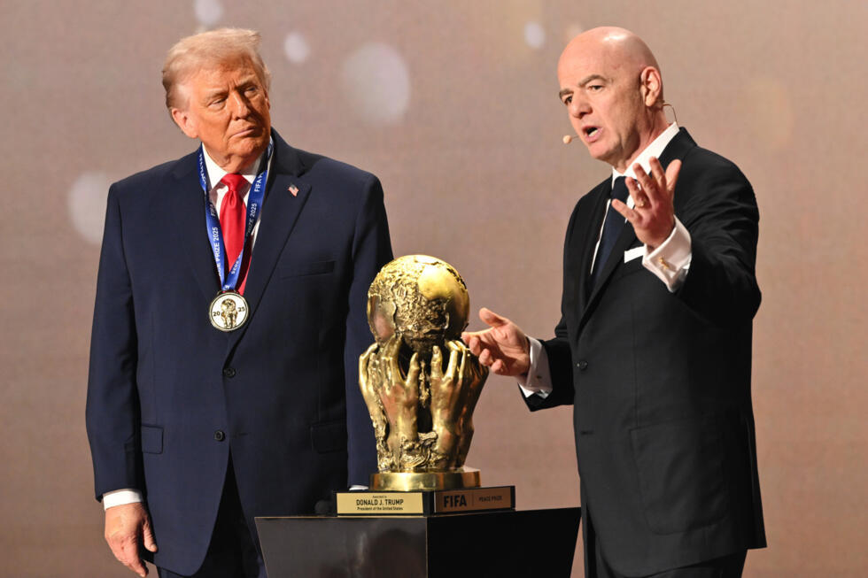 President Donald Trump looks on as FIFA President Gianni Infantino presents him with the FIFA Peace Prize during the draw for the 2026 soccer World Cup at the Kennedy Center in Washington.