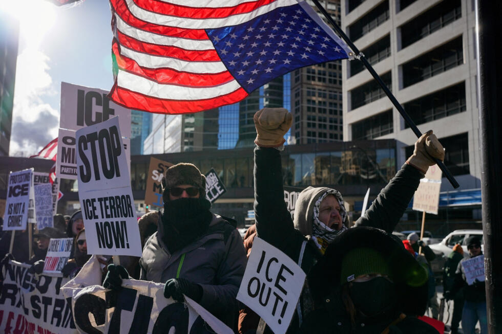 Een demonstrant houdt tijdens een demonstratie een Amerikaanse vlag ondersteboven vast