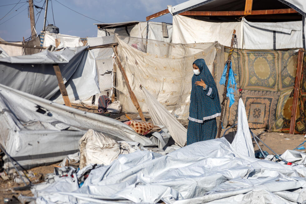 Un femme observe le site d'une frappe israélienne dans un camp de déplacés à al-Mawasi, dans le sud de la bande de Gaza, le 5 août 2025.