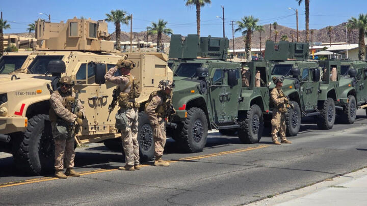 Marines stand near vehicles as they prepare to depart for Los Angeles, at an unknown location, in this handout picture released on June 9, 2025. 
