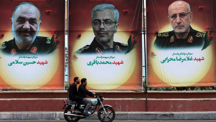 Un automobiliste passe devant des panneaux d'affichage arborant les portraits des généraux des Gardiens de la révolution iranienne Hossein Salami (à gauche), Mohammad Bagheri (au centre) et Gholamreza