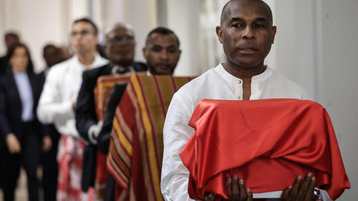 Un homme porte l'un des trois crânes sakalavas lors d'une cérémonie de restitution à Madagascar, au ministère de la Culture à Paris, le 26 août 2025.