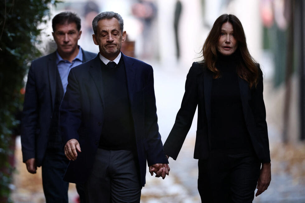Former French president Nicolas Sarkozy leaves his house with his wife Carla Bruni-Sarkozy on October 21, 2025, on his way to being admitted to La Santé prison to serve out a five-year sentence