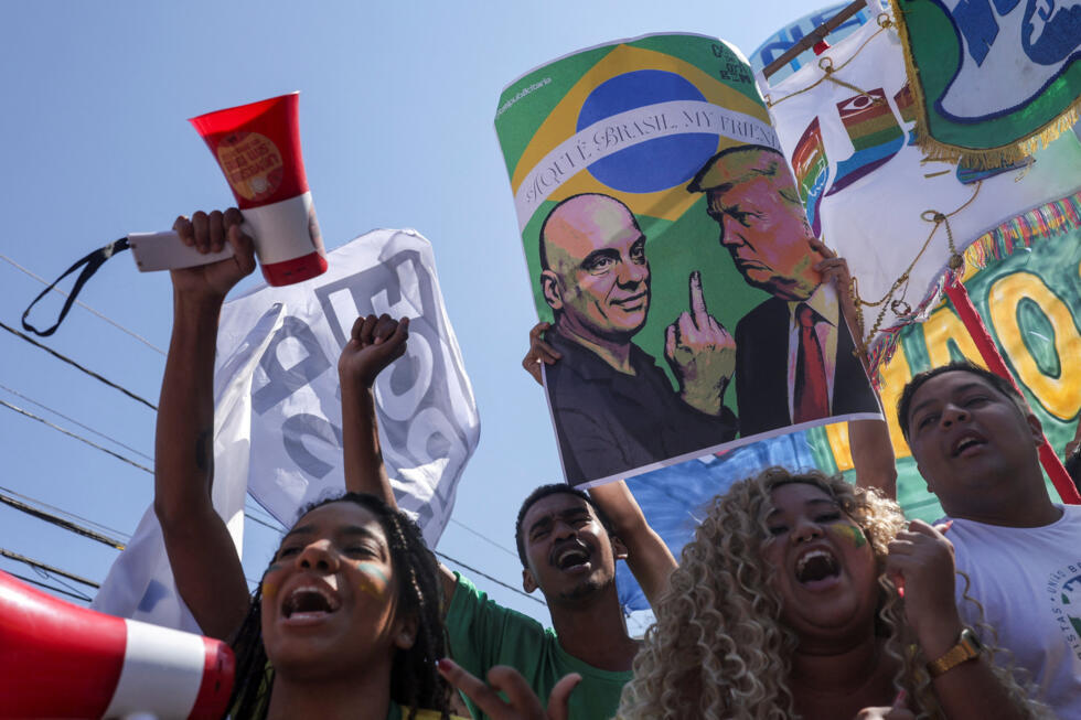 Un manifestante sostiene una pancarta con imágenes del presidente de Estados Unidos, Donald Trump, y del juez del Tribunal Supremo de Brasil, Alexandre de Moraes, en una protesta contra los aranceles impuestos por el presidente estadounidense a los productos brasileños, frente al consulado de Estados Unidos en São Paulo, Brasil, el 1 de agosto de 2025.