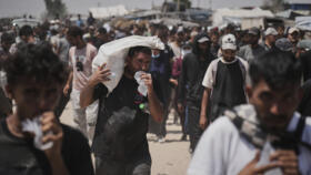 Palestinians carry bags containing food and humanitarian aid packages in Rafah, southern Gaza Strip, on June 6, 2025.