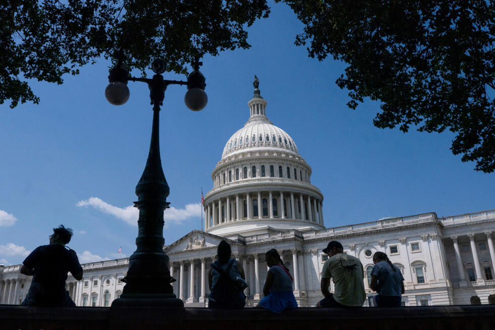 Archivo: visitantes descansan a la sombra del Capitolio de EE. UU. en Washington, D.C., el 25 de junio de 2025.