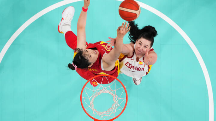 Spain's Megan Gustafson  and China's Li Yueru go for a rebound in basketball.