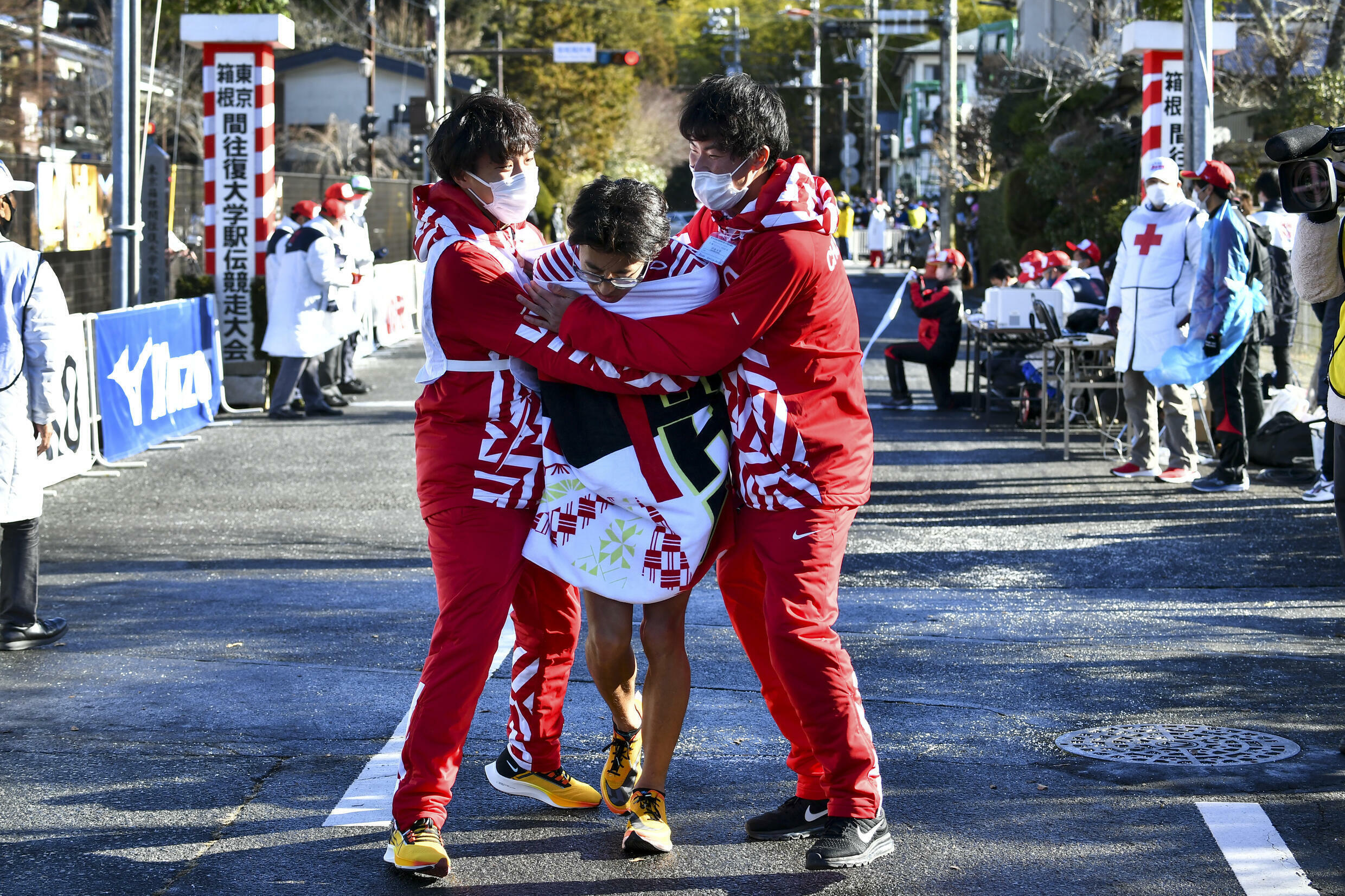 2022年1月2日、神奈川県箱根町で行われた東京・箱根生電長距離リレーの初日にフィニッシュラインを通過した後、中央大学のランナーである阿部晴樹はチームメートに助けられた。