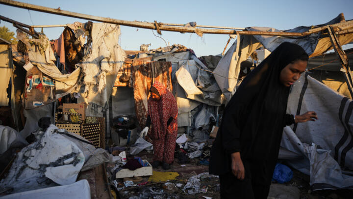 Displaced Palestinians inspect the damage after an Israeli army strike on their tent camp in Deir al-Balah in the Gaza Strip on October 29, 2025.
