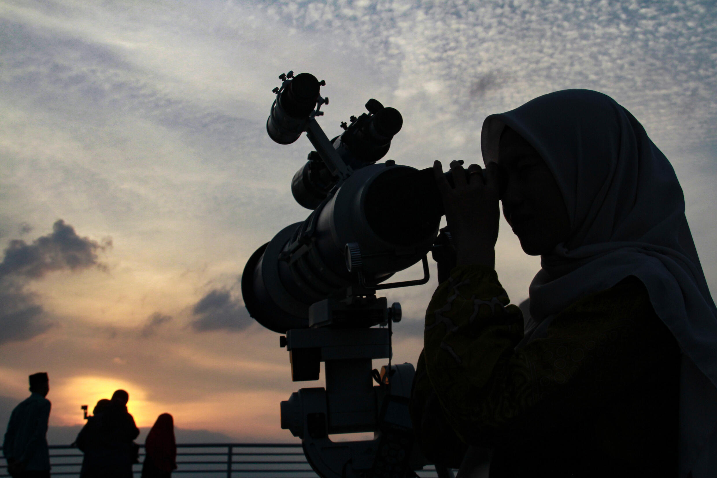 Une femme observe la lune au téléscope à la veille du mois sacré de ramadan, le 10 mars 2024 à Medan en Indonésie