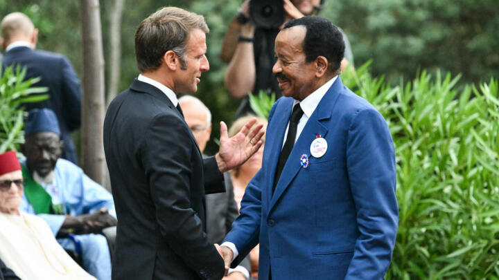 France's President Emmanuel Macron shakes hands with Cameroon President Paul Biya during a ceremony marking the 80th anniversary of the Allied landings in Provence during WWII, on August 15, 2024.