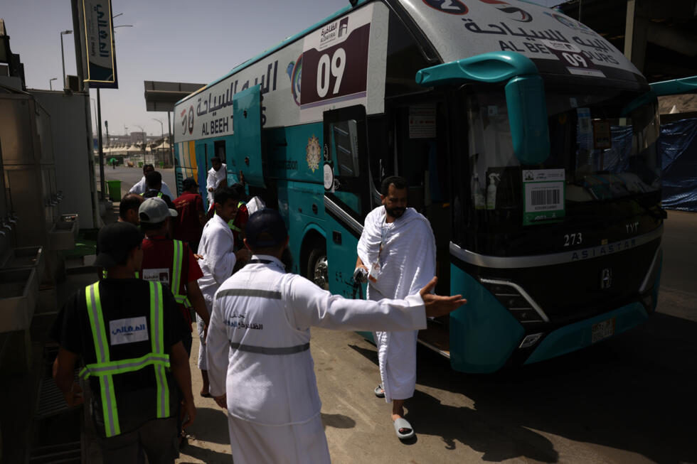 Des pèlerins musulmans descendent d’un bus à Mina, près de la ville sainte de La Mecque, le 3 juin 2025, à l’approche du pèlerinage annuel du hajj.