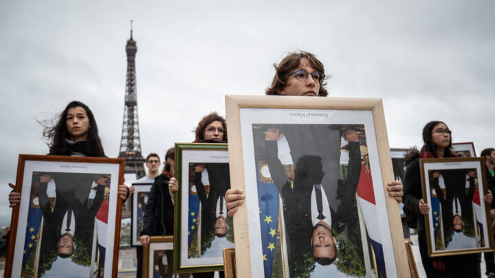 Protesters hold upside-down portraits of French President Emmanuel Macron in August 2019.