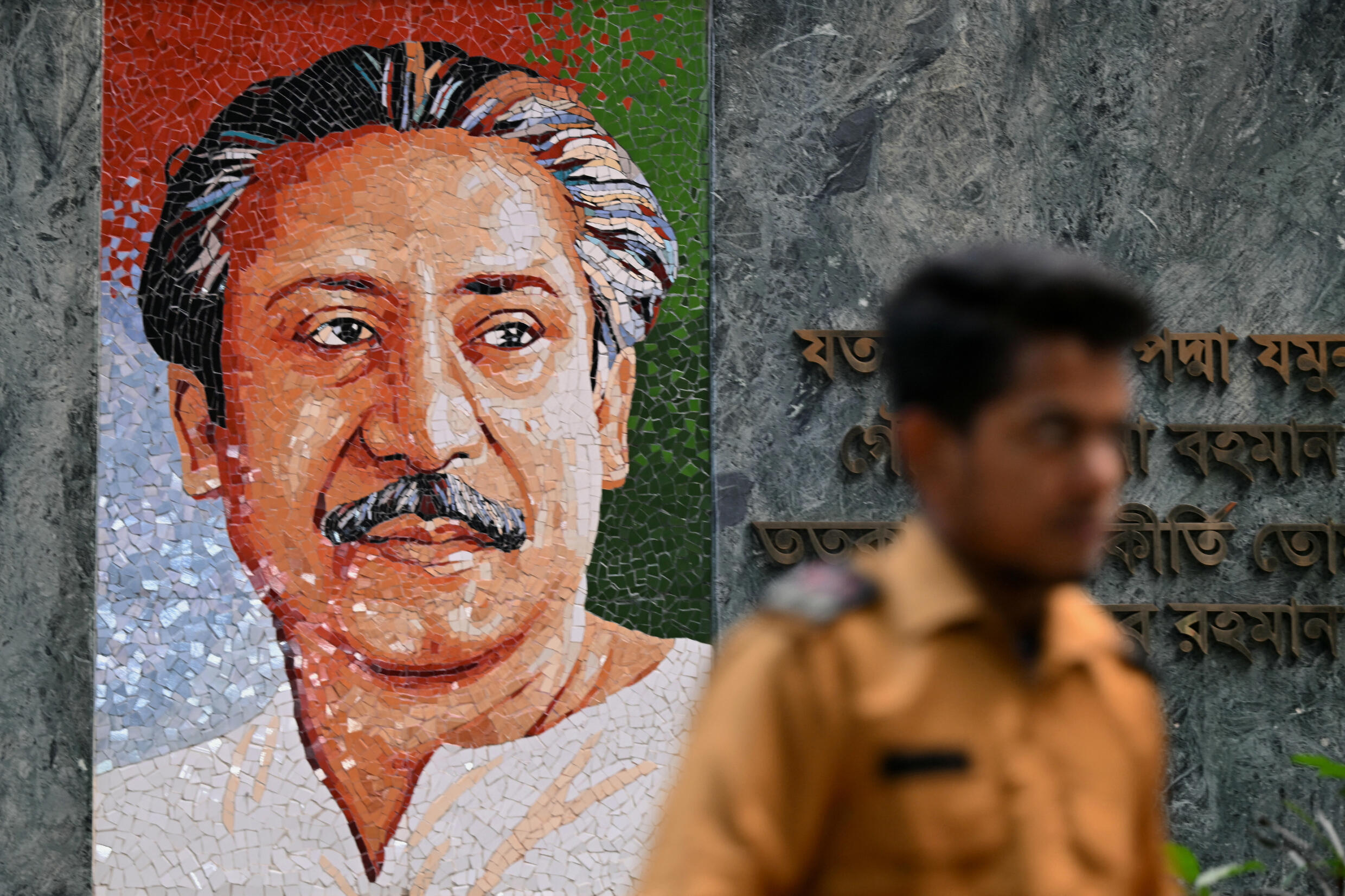 Un garde de sécurité passe devant une peinture murale du père fondateur du Bangladesh, Sheikh Mujibur Rahman, avant les prochaines élections générales, à Dhaka, le 4 janvier 2024.