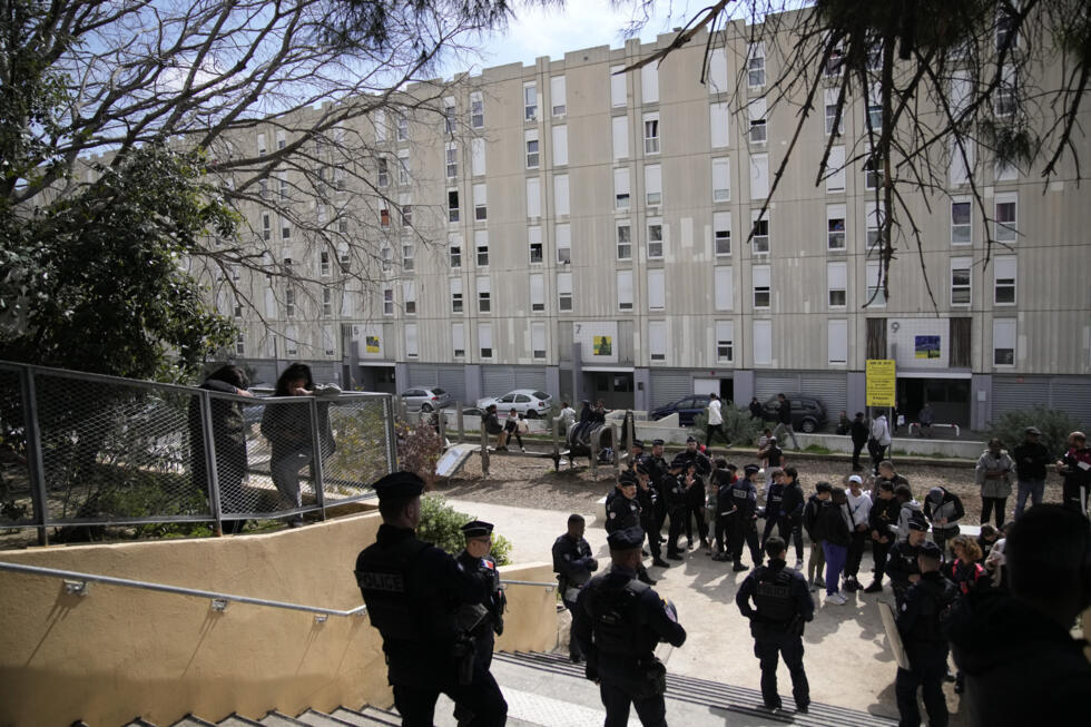 Youths and police forces during French President Emmanuel Macron's visit focusing on security and the fight against drug trafficking, Tuesday, March 19, 2024 in La Castellane district of Marseille, so