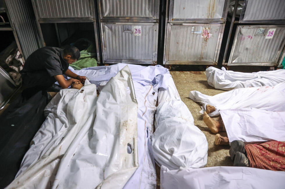 Un Palestinien pleure la mort d'un proche tué la veille par des tirs israéliens alors qu'il venait chercher de l'aide alimentaire, dans la morgue de l'hôpital Al-Shifa de Gaza-ville, le 10 août 2025.