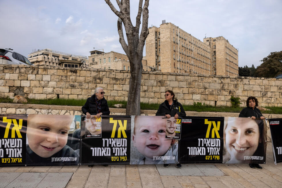 Des proches d'otages israéliens à Gaza tiennent des photos d'une mère et de ses deux enfants encore captifs, lors d'une manifestation devant le bureau du Premier ministre à Jérusalem, le 3 février 202