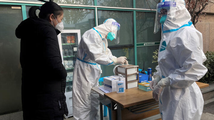 A medical worker in a protective suit registers information for a patient at the entrance to the fever clinic of the Central Hospital of Wuhan in Hubei province, China on December 31, 2022.