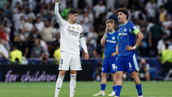 Real Madrid's Uruguayan midfielder #08 Federico Valverde (L) reacts as Marseille's Argentine defender #05 Leonardo Balerdi looks on.