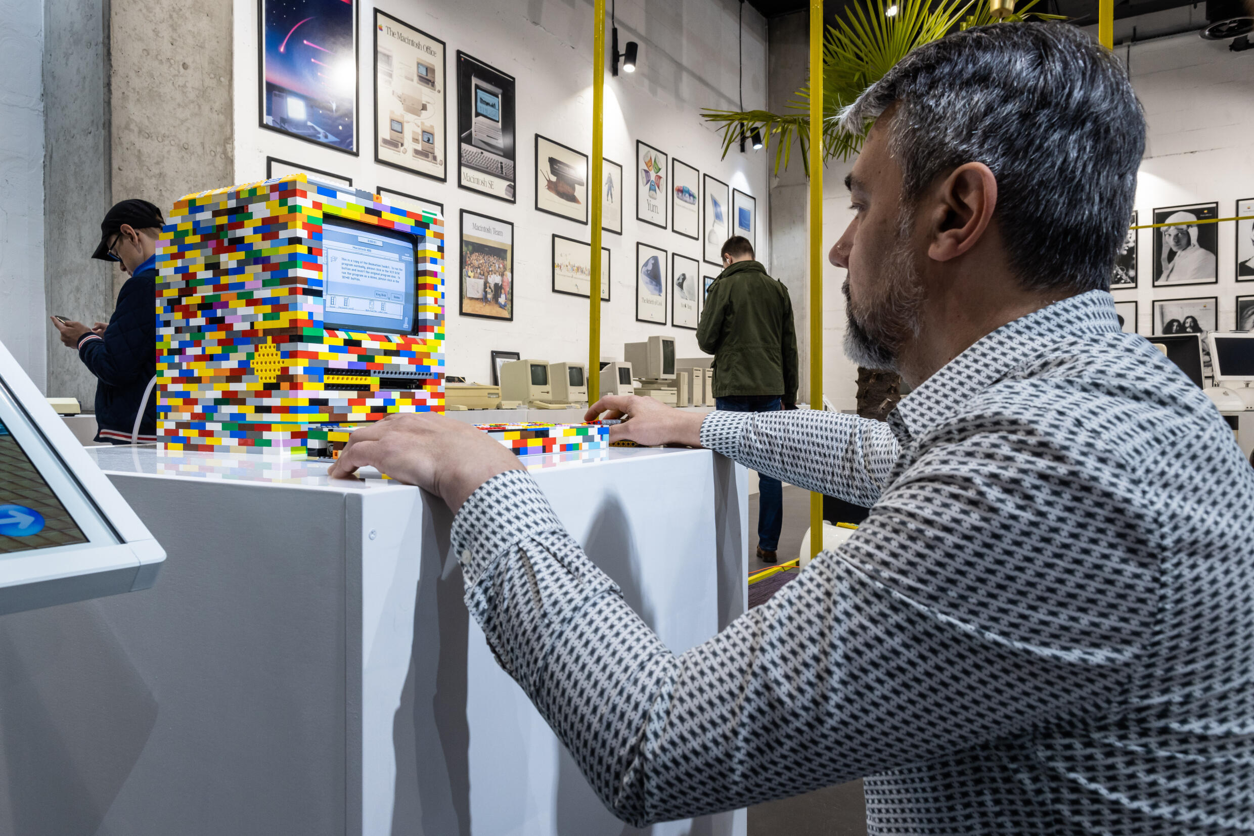 Jacek Lupina, właściciel nowego Muzeum Apple w Warszawie, 29 maja 2022 roku obsługuje komputer Macintosh złożony z klocków Lego.