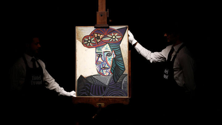 Employees adjust Pablo Picasso's "Bust of a Woman with a Flowered Hat (Dora Maar), 1943" on display before its auction in Paris, France, September 16, 2025.