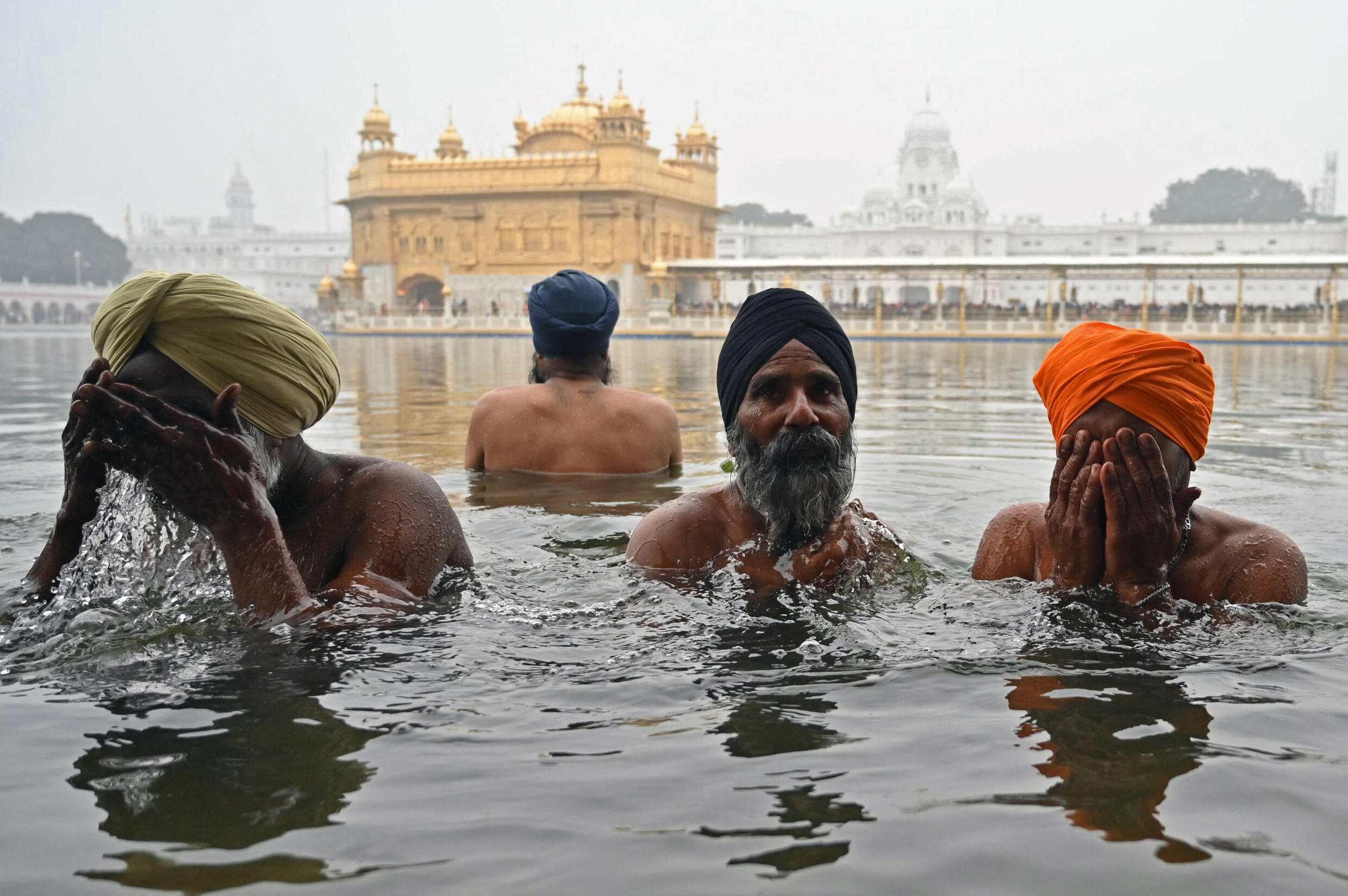 Des dévots sikhs se baignent dans le sarovar du Temple d'Or, lors des festivités du Nouvel An à Amritsar, au nord-ouest de l'État du Pendjab indien, le 1er janvier 2025.