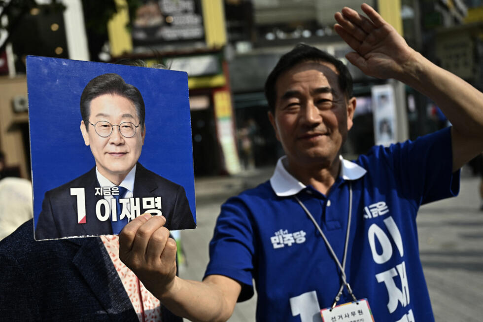 Un partisan du candidat à la présidence Lee Jae-myung du Parti démocrate tenant une pancarte lors d'un rassemblement politique en vue de l'élection présidentielle du 3 juin à Séoul le 1er juin 2025.