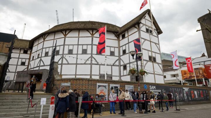 Members of the public, wearing face coverings due to Covid-19, queue for a guided tour of Shakespeare's Globe theatre in London on April 14, 2021.