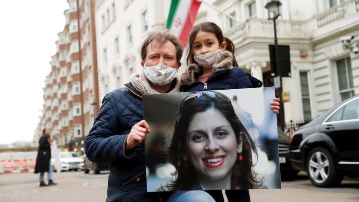 Richard Ratcliffe, husband of British-Iranian aid worker Nazanin Zaghari-Ratcliffe, and their daughter Gabriella protest outside the Iranian Embassy in London, March 8, 2021.