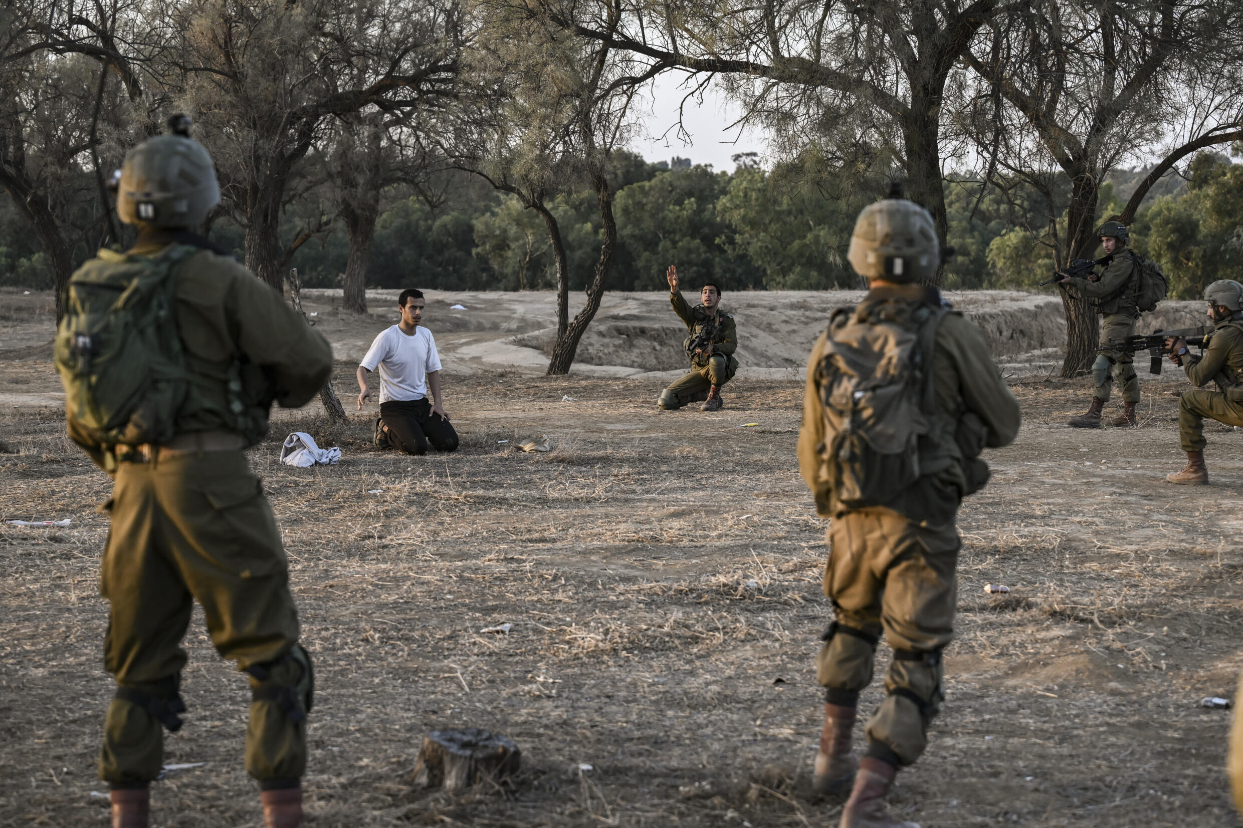 Israeli soldiers detain a man while on patrol on near Kibbutz Beeri