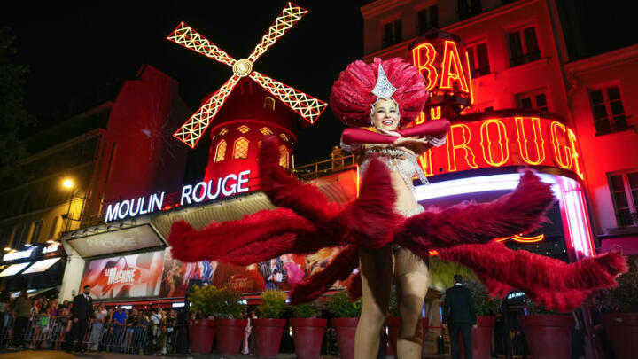 A dancer performs under the new the sails of The Moulin Rouge cabaret windmill, which went back into service 14 months after they fell off.