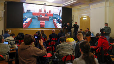 Δημοσιογράφοι συγκεντρώνονται μπροστά από μια οθόνη με ζωντανή μετάδοση ακρόασης του Ανώτατου Δικαστηρίου της Ρωσίας για να εξετάσει το κλείσιμο της ομάδας ανθρωπίνων δικαιωμάτων Memorial σε ένα δικαστικό κτίριο στη Μόσχα, Ρωσία, στις 14 Δεκεμβρίου 2021.