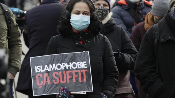 A protester holds a placard reading "Enough of Islamophobia" at a demonstration in Paris on February 14, 2021.