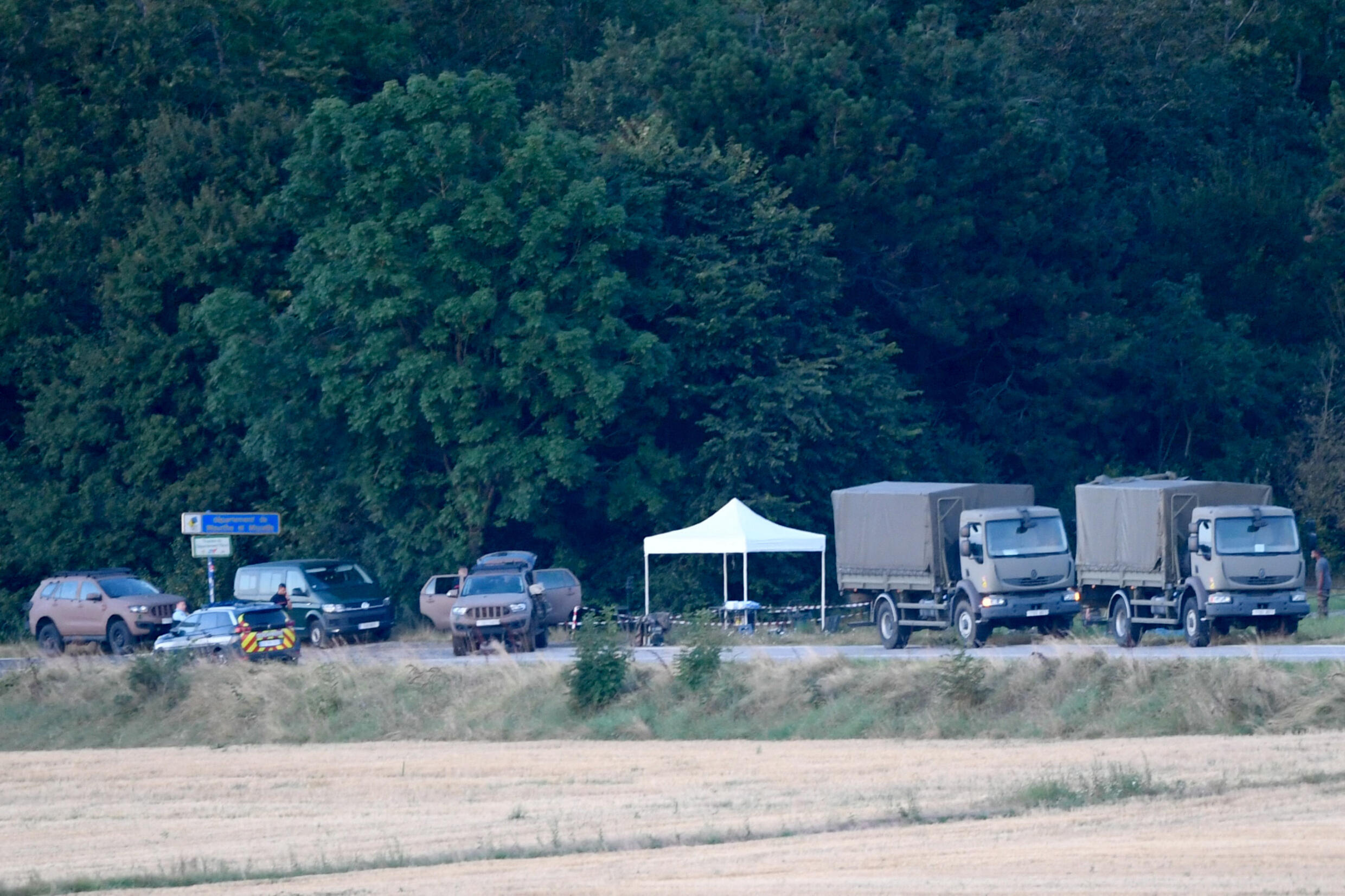 Des véhicules militaires et de la gendarmerie stationnés près de la forêt d'Autreville, après une collision entre deux avions Rafale, le 14 août 2024 dans les Vosges